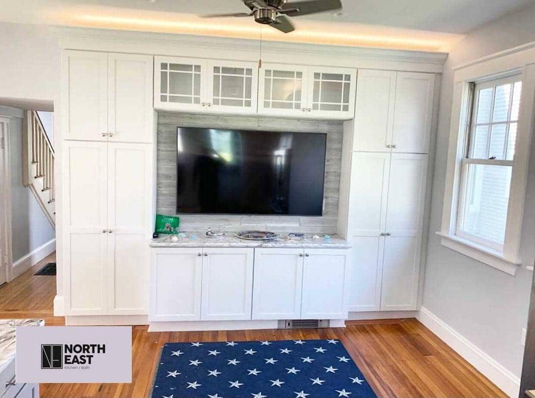 tv entertainment area surrounded by customized shelves in kitchen